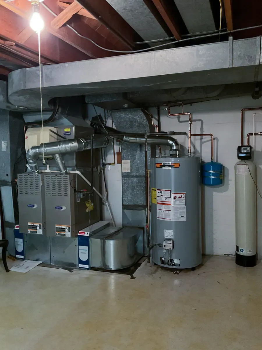 High-efficiency gas water heater installed in a Maryland basement beside a water softener and furnace